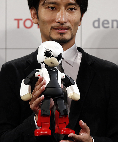 Tomotaka Takahashi, CEO of Robo Garage Co and project associate professor, research centre for advanced science and technology, the University of Tokyo, holds humanoid communication robot Kirobo during its unveiling in Tokyo