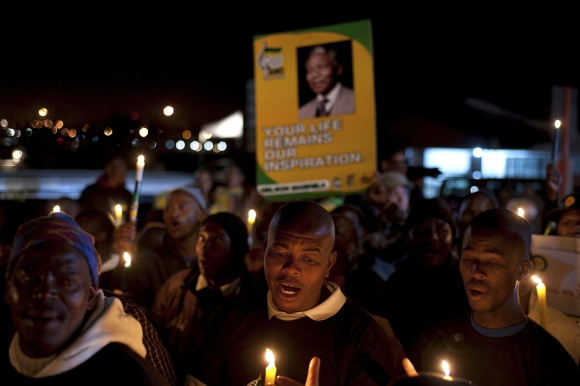 Supporters hold candles as they gather in support of Mandela in Cape Town
