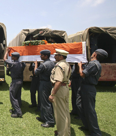 Soldiers load flag-draped coffins containing the bodies of rescue personnel who died in a chopper crash after a guard of honour ceremony in Dehradun