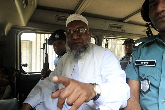 Bangladesh's Jamaat-e-Islami leader Abdul Quader Mollah gestures as he talks from a police van after the war crimes tribunal sentencing