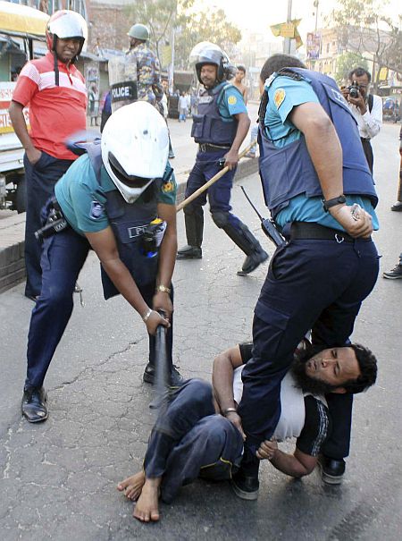 A policeman uses a baton on an activist of Jamaat-e-Islami, Bangladesh's biggest Islamist party, during a clash at Jatrabari in Dhaka