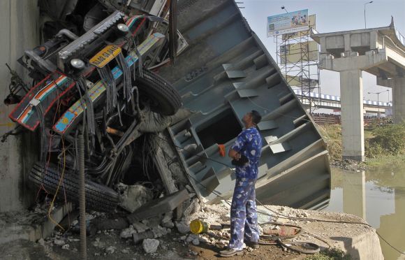 A rescue team member stands next to the wreckage of a damaged truck at the site of a collapsed flyover in Kolkata