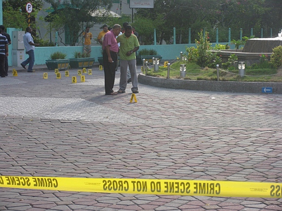 People stand near a mosque, where a blast occurred near the mosque at the entrance to the capital's Sultan Park, in this September 29, 2007 photograph