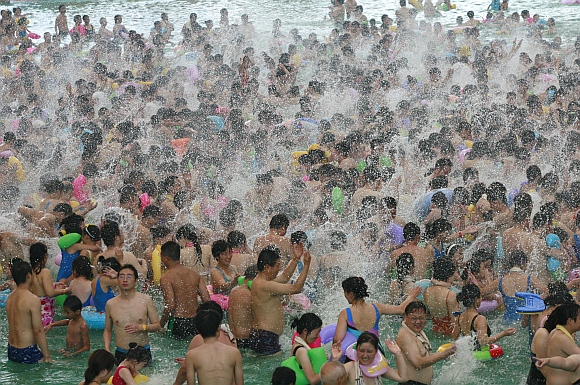 Local residents crowd a swimming pool during a hot weather in Suining, Sichuan province, China