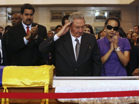Cuba's President Raul Castro salutes the coffin of Hugo Chavez. Beside him is Chavez's daughter Rosa Virginia (R), and Venezuela's Vice-President Nicolas Maduro (2nd L) at the military academy in Caracas
