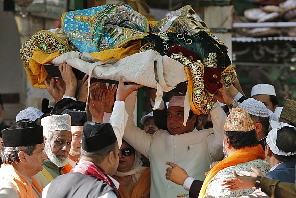 Pakistan's Prime Minister Raja Pervez Ashraf (C) carries an offering at the shrine of Sufi saint Khwaja Moinuddin Chishti at Ajmer