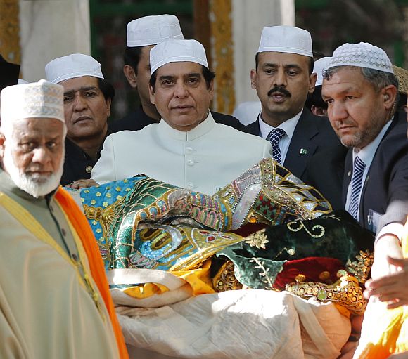Pakistan's Prime Minister Raja Pervez Ashraf (C) carries an offering at the shrine of Sufi saint Khwaja Moinuddin Chishti at Ajmer