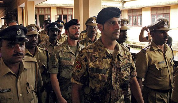 File photo shows Salvatore Girone (C) and Latorre Massimiliano (3rd R), members of the navy security team of Napoli registered Italian merchant vessel Enrica Lexie, being escorted as they leave a courtroom at Kollam, Kerala