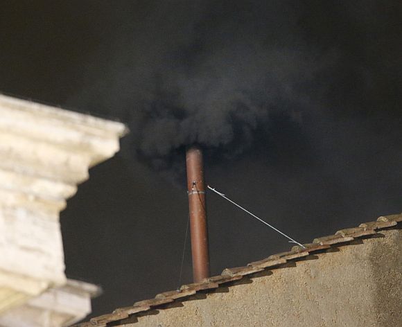 Black smoke rises from the chimney on the roof of the Sistine Chapel in the Vatican City indicating that no decision has been made after the first day of voting for the election of a new pope