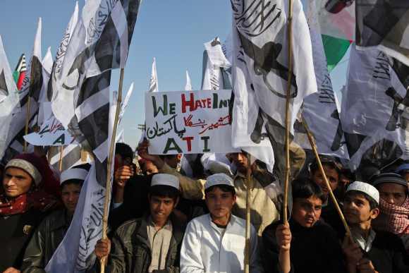 Supporters of the Jamaat-ud-Dawa Islamic organisation hold placardand party flags as they take part in an anti-India demonstration to condemn the hanging of Mohammad Afzal Guru, in Rawalpindi