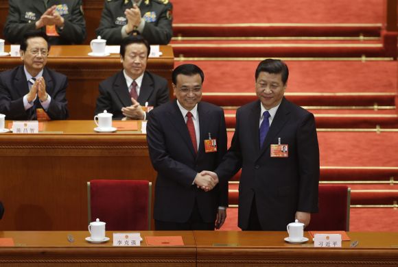 China's President Xi Jinping (R) shakes hands with China's newly-elected Premier Li Keqiang during the fifth plenary meeting of the National People's Congress (NPC) at the Great Hall of the People in Beijing