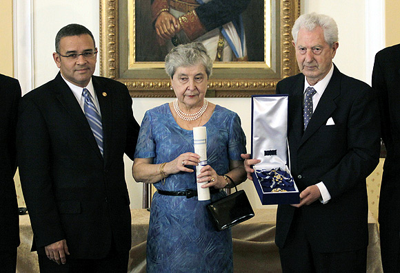 El Salvador's President Mauricio Funes (left) presents a medal to Juan Antonio Ellacuria, brother of Spanish-born Jesuit priest Ignacio Ellacuria, and his wife Manuela Balenciaga, on the 20th anniversary of his brother's murder, in San Salvador, November 16, 2009.