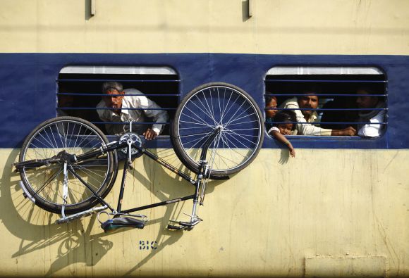 A bicycle hangs from the window of a train at Parsha Bazar railway station in Bihar