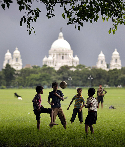 Children play soccer against the backdrop of the Victoria Memorial in Kolkata built as a tribute to Queen Victoria in the early 20th century.