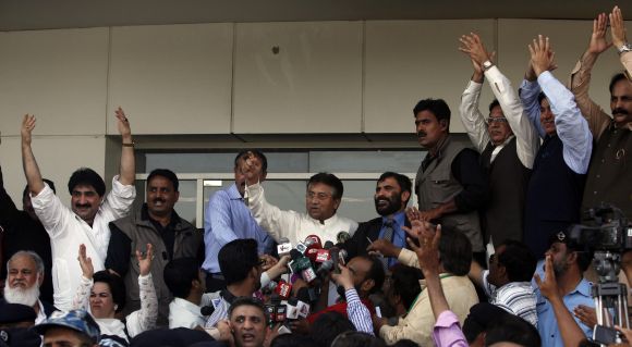 Musharraf gestures to his supporters upon his arrival at Karachi airport