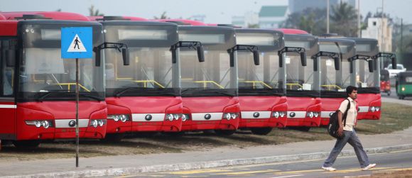 A man walks past China-made buses in Colombo