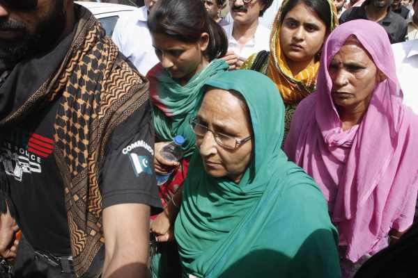 Pakistani security officials escort Dalbir Kaur, sister of Sarabjit Singh, as she arrives with her family members at Jinnah hospital in Lahore April 28. Singh was attacked and seriously injured by fellow inmates in Lahore's Kot Lakhpat Jail last Friday and died on Thursday
