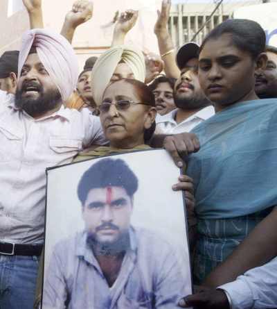 Family members of Sarabjit Singh hold his picture