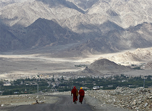 Buddhist monks walk on a road in Stok, 20 km north of Leh