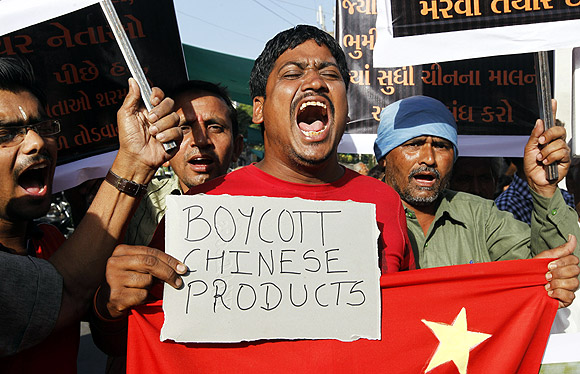 Traders shout slogans during a protest against China