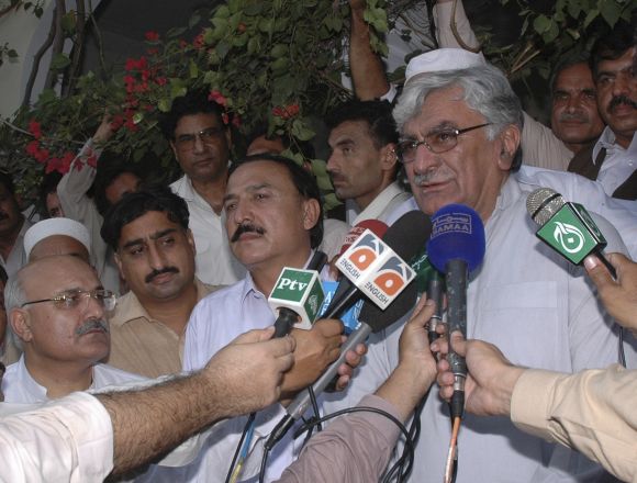 Asfandyar Wali Khan (right), leader of the Awami National Party, speaks to the media