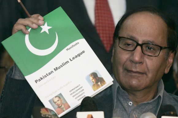Pakistan Muslim League (PML) President Chaudhry Shujaat Hussain shows the media his party manifesto during a news conference in Islamabad