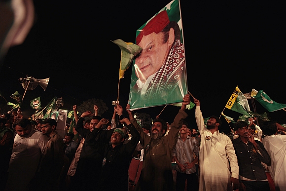 Supporters of the PML-N hold the portrait of party leader Nawaz Sharif as they shout slogans during an election campaign rally in Rawalpindi.