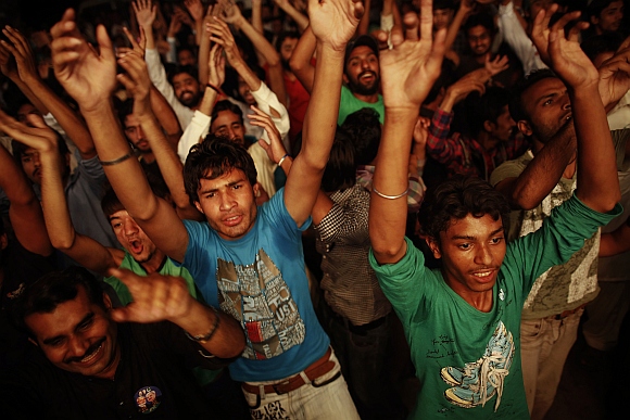 Supporters of the PML-N celebrate in front of a party office as results of the general election come in, in Lahore