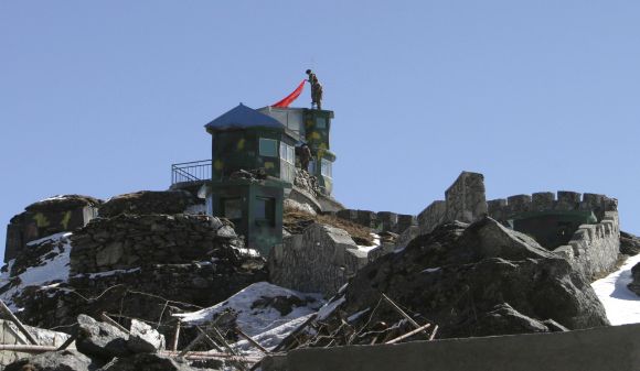A Chinese soldier put up a flag atop their post at the Indo-China border in Nathula Pass in Sikkim