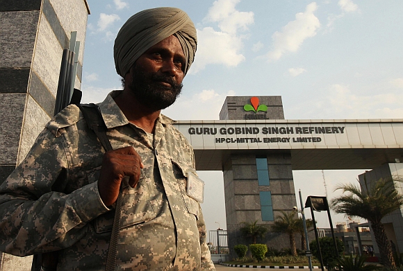 A security personnel stands guard in front of the main entrance of the Guru Gobind Singh oil refinery near Bhatinda in Punjab
