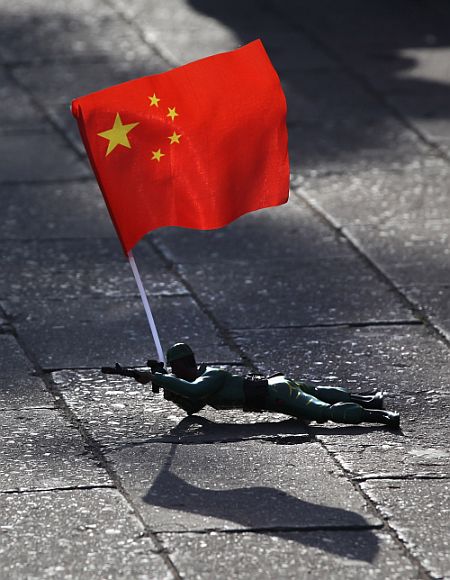 A electric toy soldier crawls on the ground outside the Forbidden City in Beijing, China