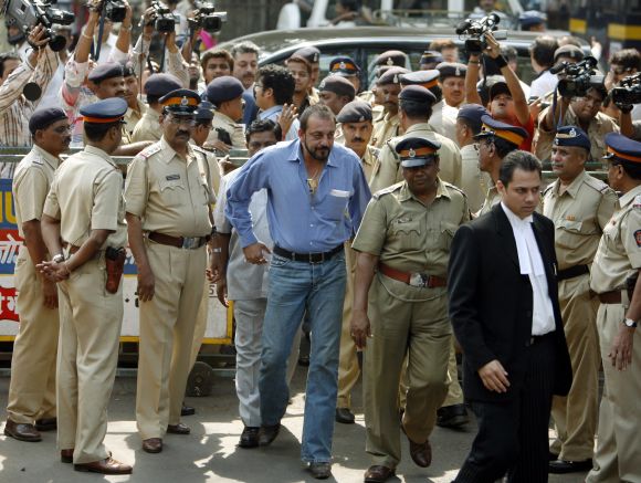 Sanjay Dutt, escorted by policemen, follows his lawyer as he arrives at a special court in Mumbai