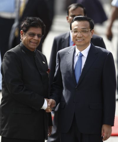 Li Keqiang shakes hands with Minister of State for External Affairs E Ahmed upon his arrival at the airport in New Delhi.
