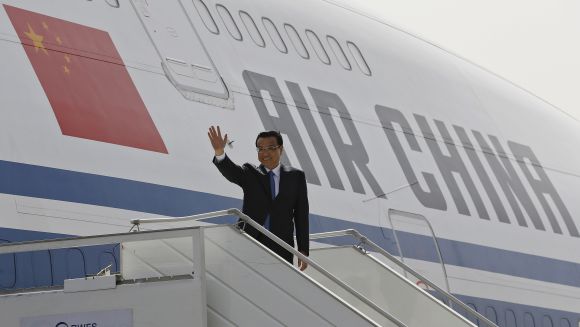 Chinese Premier Li Keqiang waves upon his arrival at the airport in New Delhi