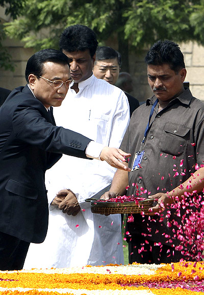 Chinese Premier Li Keqiang scatters rose petals at the Mahatma Gandhi memorial at Rajghat