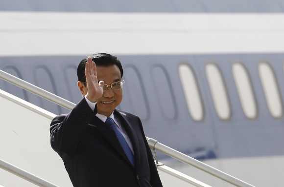 Li Keqiang waves upon his arrival at the airport in New Delhi