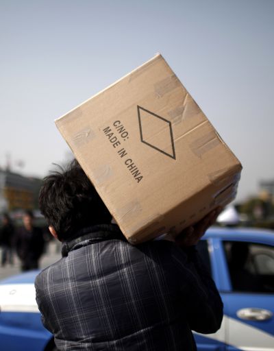 A man carries a box with products made in China at a wholesale market in Yiwu, Zhejiang province.