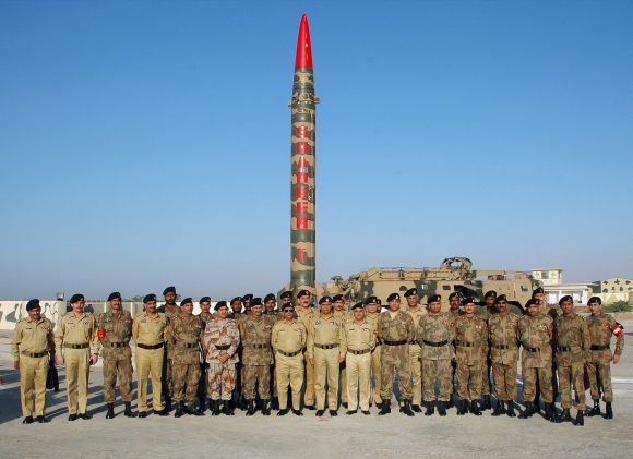 Pakistan's army officials pose for a photograph with the nuclear-capable Hatf missile during a test launch