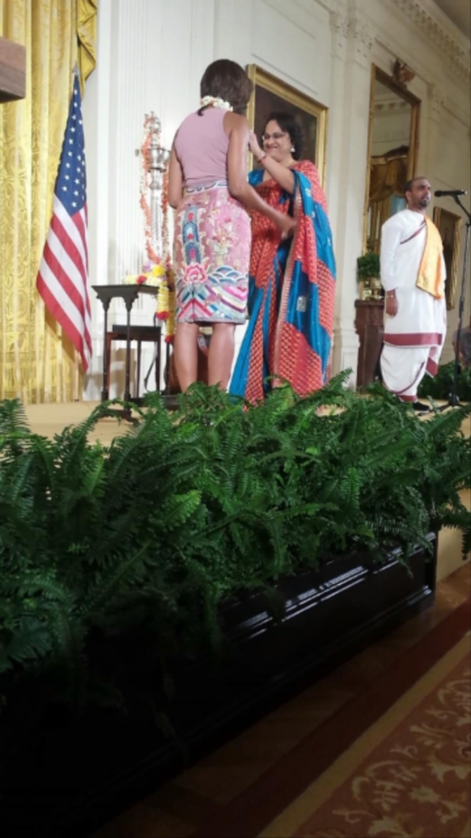 Mythili Bachi chairperson the Sri Siva Vishnu Temple garlands Michelle Obama at the Diwali celebrations