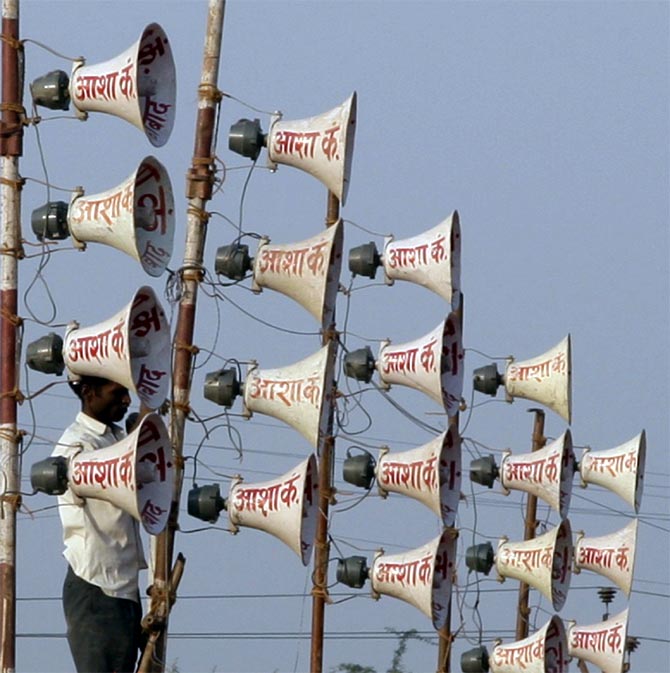 A worker installs loudspeakers at the venue of a campaign rally on the outskirts of Allahabad, 2011.