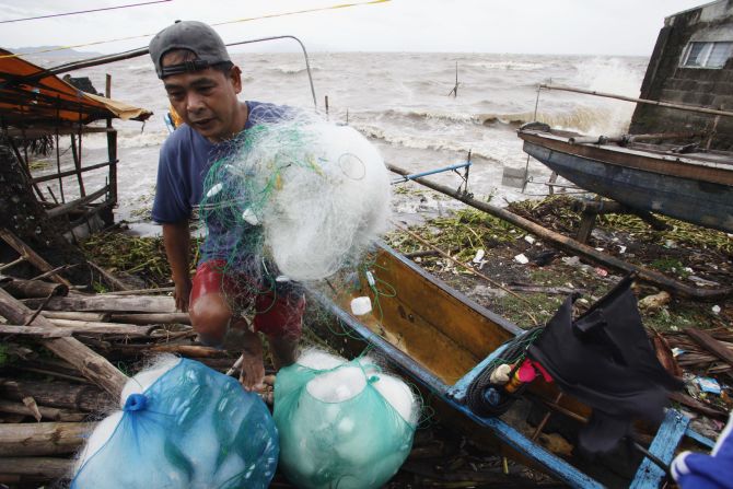 A fisherman carries his net after making it safely back to shore after a strong winds from Typhoon Haiyan battered Bayog town in Los Banos, Laguna city, south of Manila, on Friday. 