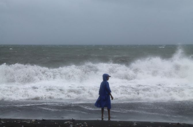 A resident walks along a shoreline as strong winds brought by super Typhoon Haiyan battered San Roque town, Legazpi city, south of Manila 
