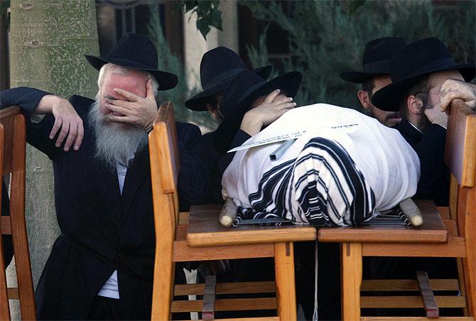 A mourner besides the body of Rabbi Gavriel Holtzberg during the funeral for him and his wife, Rivka, in Kfar Chabad near Tel Aviv. The Rabbi and wife were killed in the 26/11 terror attacks.