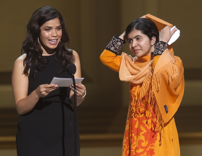 Actor America Ferrera speaks as Malala Yousafzai looks on after receiving her award during the Glamour Magazine Women of the Year event in New York