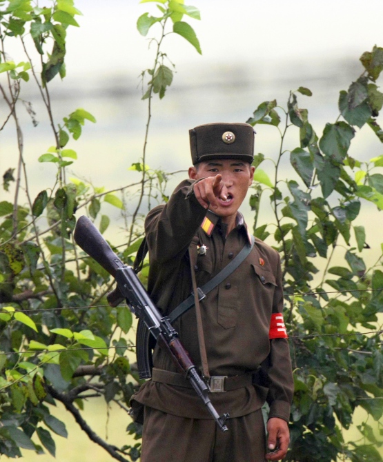 A North Korean soldier points at visitors near the North Korean town of Sinuiju, opposite the Chinese border city of Dandong.