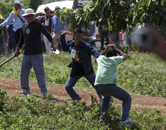 Supporters of the Thailand's People's Alliance for Democracy scuffle with a villager during a march along a highway leading to the Preah Vihear temple