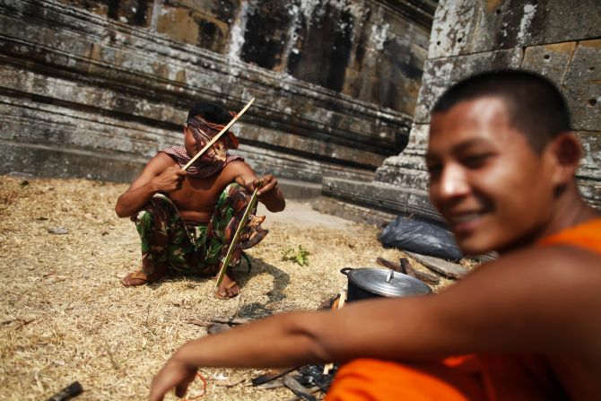 A Buddhist monk and a Cambodian soldier prepare food at the 11th-century Preah Vihear temple