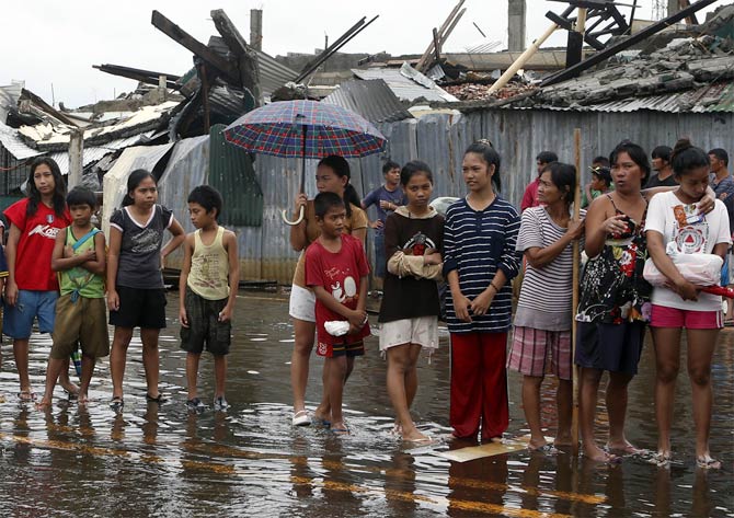 Typhoon victims queue up for free rice at Tacloban city, which was battered by Typhoon Haiyan, in central Philippines
