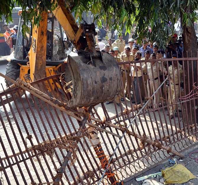 A bulldozer forces down the gate at the Campa Cola compound.