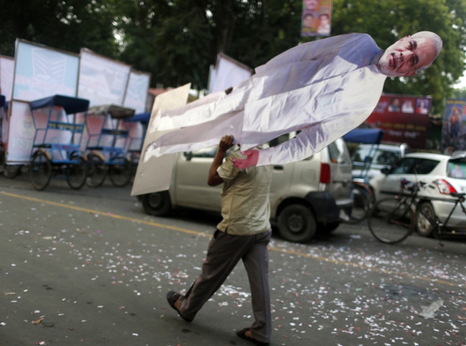 A BJP supporter carries a cutout of Narendra Modi outside the party headquarters in New Delhi